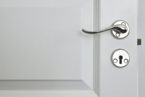 Metallic door knob on a classic white door. Home interior